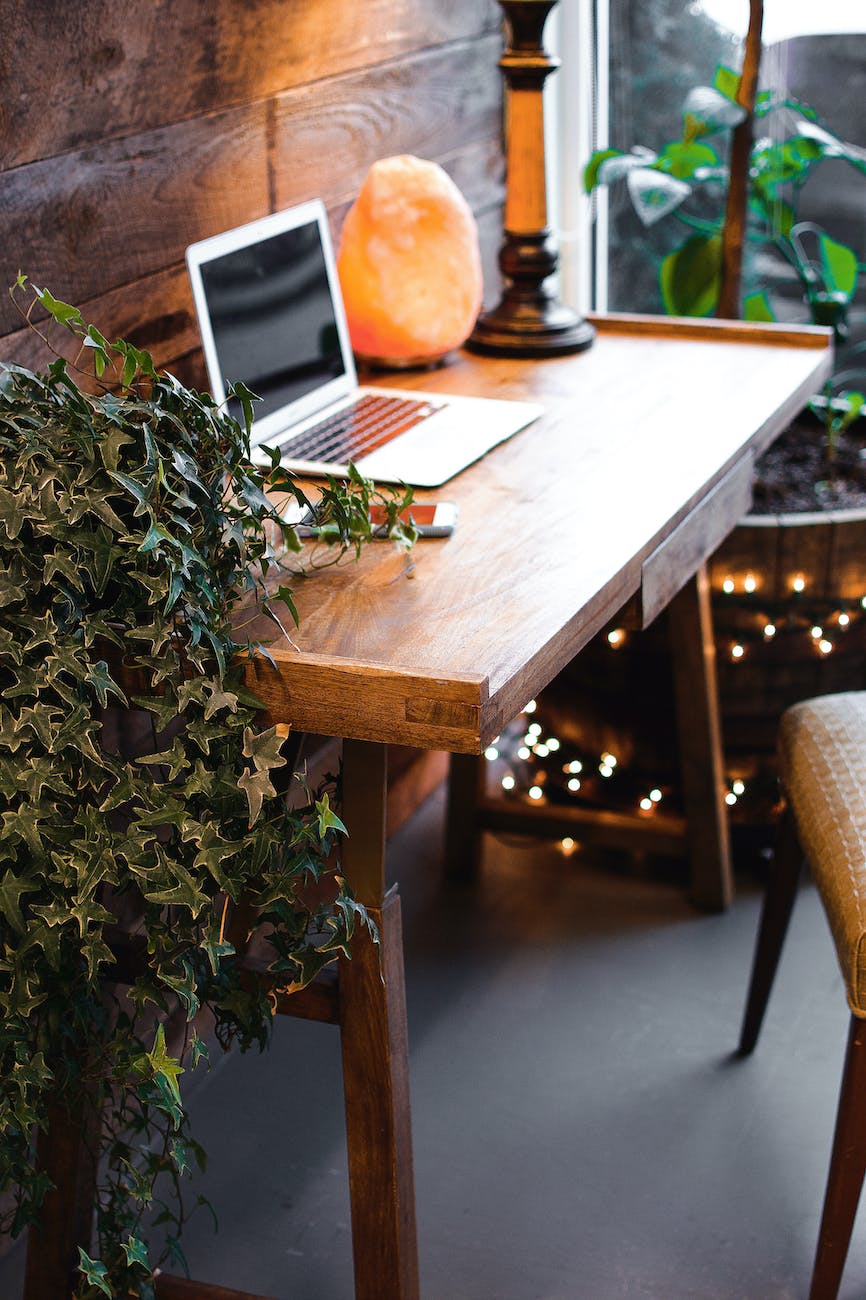 himalayan salt lamp near laptop on wooden table